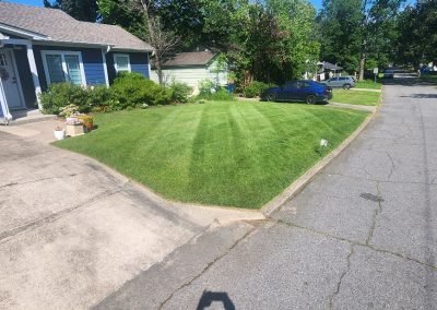 1333x616.jpeg.b1c843c00a004dddbeb2f6aa7868421e Lawn care service showcasing a well-maintained green lawn with striped patterns, bordered by a residential driveway and flower pots, highlighting APEX Lawn Care's professional landscaping in Central Arkansas.