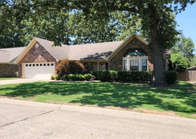 Suburban single-story office with a brown roof, beige sidings, and an attached double garage on a sunny day. - Little Rock Lawn Care and Mowing Services by Apex Lawn Care Well-maintained residential lawn and landscaping showcasing APEX Lawn Care services in Little Rock, Arkansas.