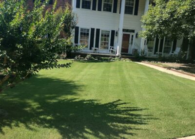 Two-story suburban office with a well-manicured lawn and white columns. - Little Rock Lawn Care and Mowing Services by Apex Lawn Care Lush green lawn in front of a residential home with well-maintained landscaping, showcasing APEX Lawn Care's professional lawn care services in Little Rock, Arkansas.