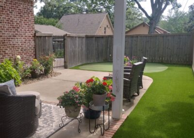 A well-maintained backyard patio with artificial grass, outdoor furniture, and potted flowers showcasing a well-maintained backyard patio with artificial grass, outdoor furniture, and potted flowers. - Little Rock Lawn Care and Mowing Services by Apex Lawn Care Lush green artificial turf and landscaped patio area with potted flowers, showcasing APEX Lawn Care's professional lawn care services in Little Rock, Arkansas.