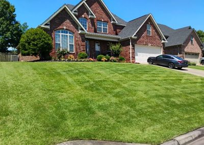large-21 Well-maintained green lawn in front of a brick house, showcasing professional lawn care services by APEX Lawn Care in Central Arkansas.
