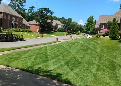 large-22 Lush green lawn with neatly striped patterns, showcasing professional lawn care services in a residential neighborhood in Central Arkansas, highlighting APEX Lawn Care's quality work.