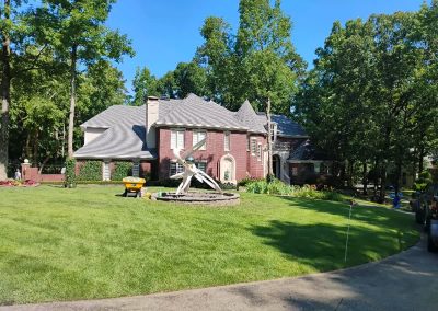 large-26 Lawn care service showcasing a well-maintained residential property in Central Arkansas, featuring lush green grass and landscaped garden with decorative elements.
