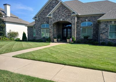 large-5 Well-maintained lawn and landscaped entrance of a residential property, showcasing APEX Lawn Care's professional lawn care services in Central Arkansas.